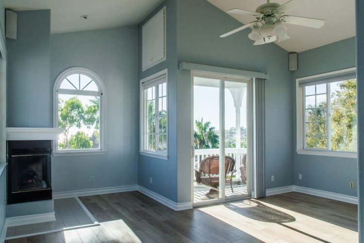 A trendy modern interior of a living room with blue walls and white windows